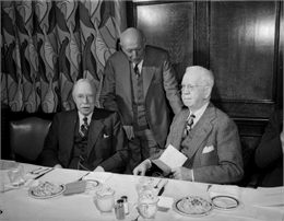 Three members of the board of curators of the State Historical Society of Wisconsin sit at a banquet table.