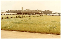 four large factory buildings with smokestacks