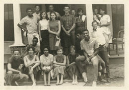 Group of young adults standing on porch of house