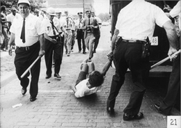 Police drag a young black woman towards a police vehicle