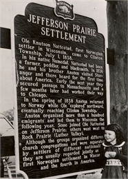 Photograph of a young girl posing with the historic marker for the Jefferson Prairie Settlement