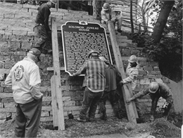 Photograph of construction workers installing historic marker for Solomon Juneau House