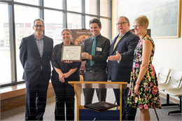 Photograph of Neville Public Museum staff and Christian Overland posing with Museum Exhibit Award certificate