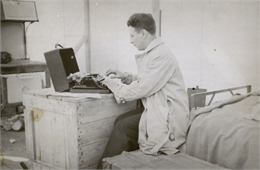 Arville Schaleben, of The Milwaukee Journal, writes a story in the tent he shared with others in the summer of 1935, in the Matanuska valley of Alaska.