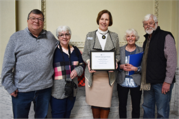 State Historic Preservation Officer Daina Penkiunas presents a certificate to Rudy Winther, Arthur Cybul, Renee Cybul, and Jean Winther