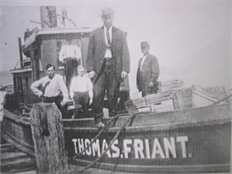 A historic, black and white photo of five men standing on a fish tug boat