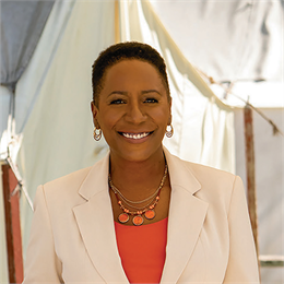 A professional headshot of Christy S Coleman smiling wearing business attire.