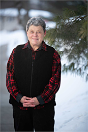 Photo of Peggy Marxsen wearing a black puffer vest and red and black plaid shirt