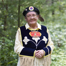 Photograph of Valerie Barber wearing an eagle feather beret and vest reading USMC Woman Veteran