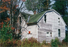 Exterior of farm house with paint peeling.