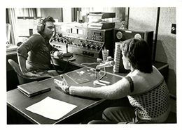 A student sitting in front of a microphone in the fledgling radio station