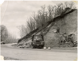 Bulldozer and truck excavate turn 11 near the kink in spring 1955.