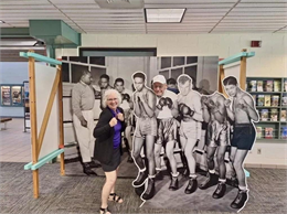 Two people posing with large-scale interactive display of historical photo of Milwaukee Urban League boxing program.