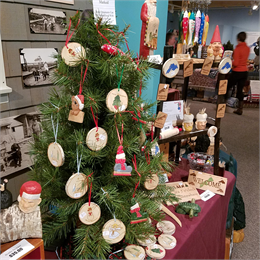 A small Christmas tree decorated with wooden ornaments in a shop