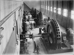 A man stands near the generators inside the power house.