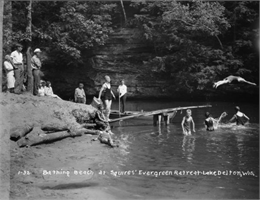 A group of swimmers in bathing suits along the shores of Lake Delton.